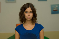 Imagen en primer plano de una chica joven con una camiseta de manga corta azul.