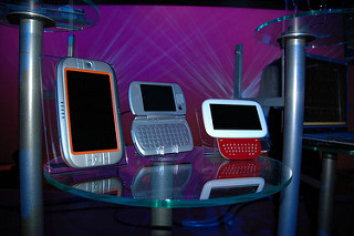 Varios dispositivos informáticos móviles sobre una mesa en exposición.