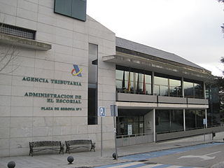 Foto de la fachada y puerta de entrada al edificio de la Agencia Tributaria, Administración de El Escorial.
