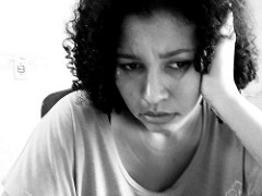 Foto en blanco y negro en la que se ve un plano medio de una mujer, con cara dce preocupación, apoyando la cabeza en su mano, y con la mirada perdida.