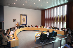 En una mesa con forma de V, están sentados todos los representantes municipales de un ayuntamiento.