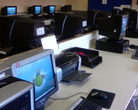 Imagen que muestra una sala de ordenadores. Éstos están encendidos y no hay nadie en la sala en ese momento.