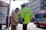 Un policía local frente a un señor mayor en calle soleada