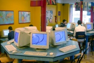 Una sala donde en el centro hay una mesa octogonal con 8 ordenadores.