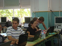 Tres chicos y una chica trabajando con sus ordenadores.