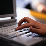 Una mano pulsa una tecla en un teclado de un ordenador.