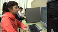 Programadora codificando un programa frente a una pantalla de ordenador.