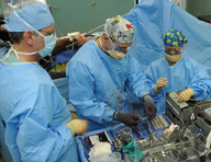 Varias personas operando en un quirófano.