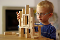 Niño reutilizando las piezas de un juego para hacer su propia construcción.