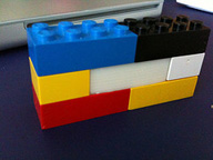 Piezas de lego de distintas formas y colores ensambladas formando un muro.