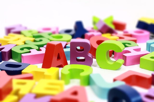 Montón de piezas con forma de letras desordenadas y tumbadas, y entre ellas, de pie, las letras A, B y C, en orden.