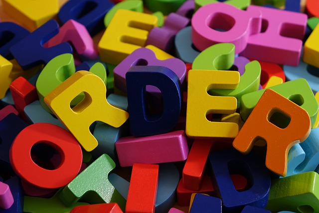 Piezas con forma de letras diferentes, amontonadas y desordenadas, salvo las que forman la palabra ORDER sobre las demás.