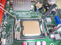 Muestra un zócalo del tipo LGA con las sujeciones abiertas  y un procesador colocado en el zócalo.