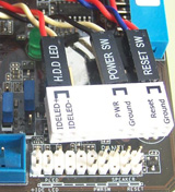 Muestra el conector auxiliar con los cablecitos del frontal conectados  a punto de ser insertado en el conector de la placa base.