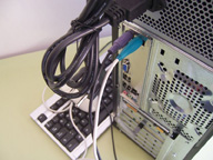 Vista posterior de la caja del ordenador  con el teclado y el ratón  conectados. El ratón  ha sido conectado  a su conector correspondiente, el de color verde,  de la placa base.